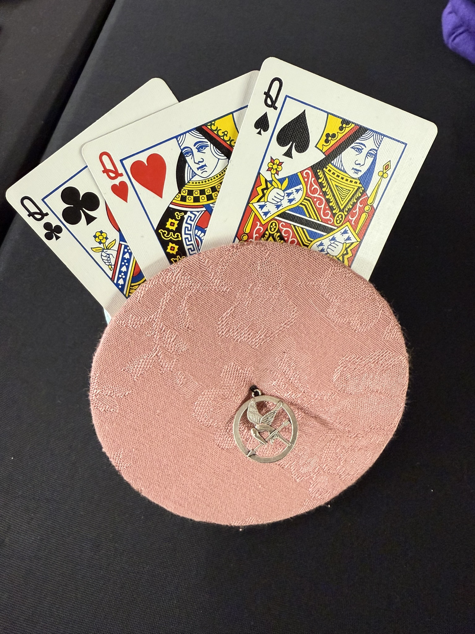 muted pink playing cards holder with hunger games charm